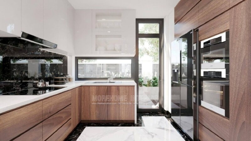Với cách sắp xếp nội thất độc đáo, mẫu phòng bếp hiện đại trong đây sẽ là một ý tưởng tuyệt vời cho các không gian như nhà phố có sân vườn, biệt thự,.. Lối đi ra ngoài sân vườn, bạn có thể tận dụng trồng những cây rau thơm, gia vị; cánh cửa kính trắng giúp bạn có thể vừa nấu ăn vừa theo dõi hoạt động ngoài trời của con. Nội thất phòng bếp